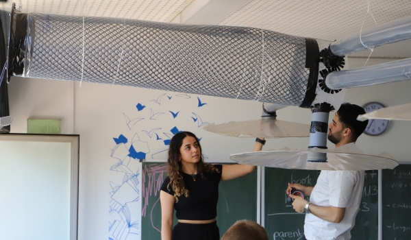 Zwei Studierende montieren Lüftungsanlage in Klassenzimmer