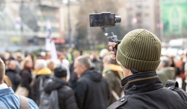 Mann filmt Kundgebung mit Handy