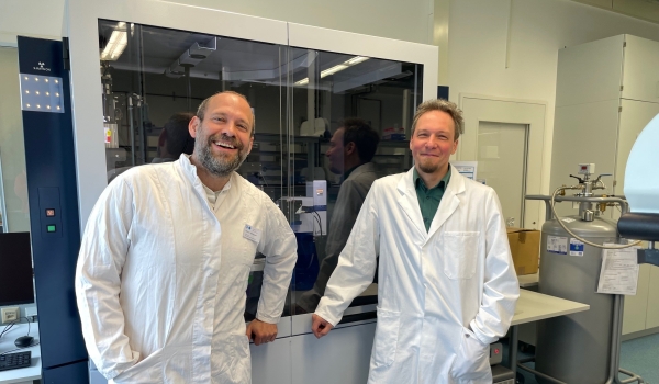 Fröhliche Wissenschaftler in weißen Kitteln im Labor