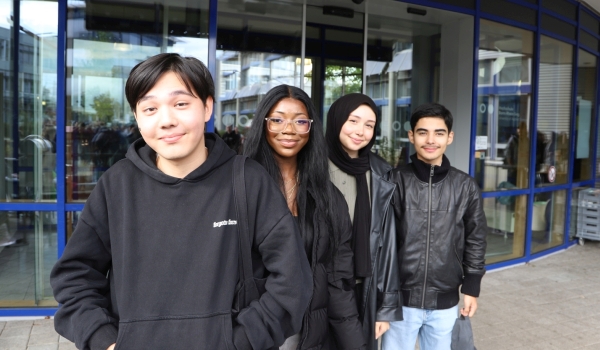 Gruppe gut gelaunter Studierender vor Haupteingang