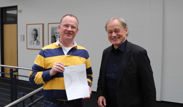 Professor neben Präsident im Flur
