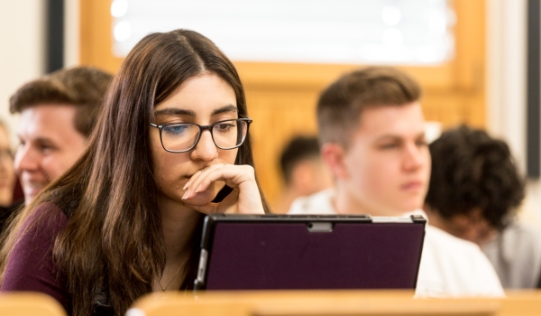 Nachdenkliche Studentin am Laptop in der Vorlesung