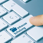 Auf einer Computertastatur steht "Inhouse-Schulung".